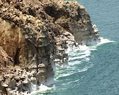 Dead Sea in Jordan. Waves splash to rocks covered with crystals of salt. Video stock 114413207