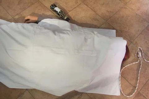 Dead woman's corpse after hanging herself with a rope and a bottle of spirits Stock-Fotos