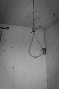 Deadly loop hanging from the ceiling in abandoned apartment. Concept of suicide Stock Photos