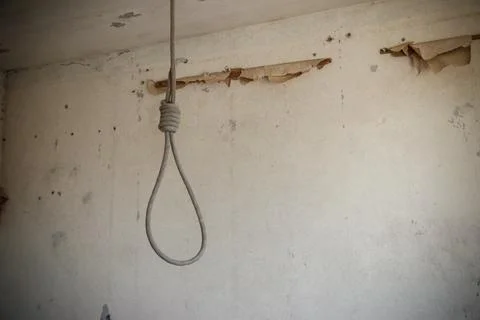 Deadly loop hanging from the ceiling in abandoned apartment. Concept of suicide Stock Photos