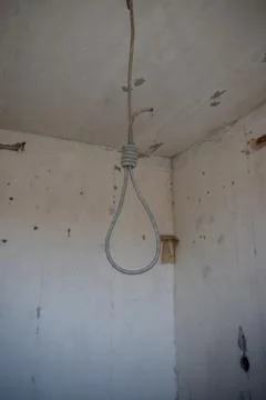 Deadly loop hanging from the ceiling in abandoned apartment. Concept of suicide Stock Photos