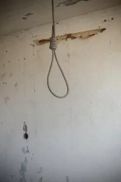 Deadly loop hanging from the ceiling in abandoned apartment. Concept of suicide Stock Photos