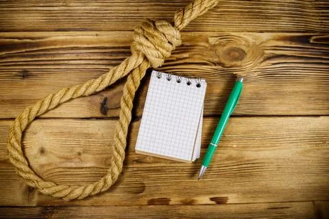 Deadly loop of rope and suicide note on a wooden background. Concept of suicide Stock Photos