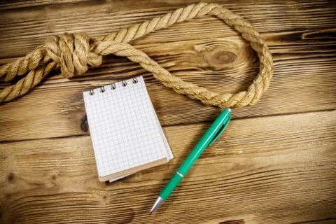 Deadly loop of rope and suicide note on a wooden background. Concept of suicide Stock Photos