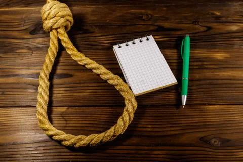 Deadly loop of rope and suicide note on a wooden background. Concept of suicide Stock Photos