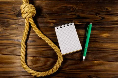 Deadly loop of rope and suicide note on a wooden background. Concept of suicide Stock Photos