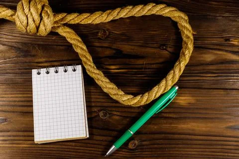 Deadly loop of rope and suicide note on a wooden background. Concept of suicide Stock Photos