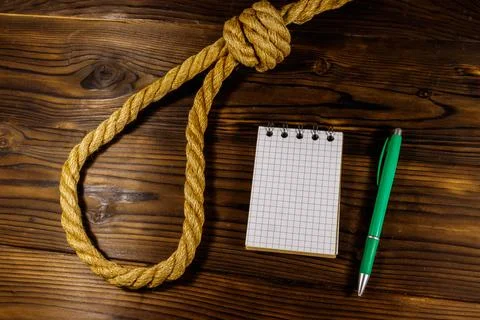 Deadly loop of rope and suicide note on a wooden background. Concept of suicide Stock Photos