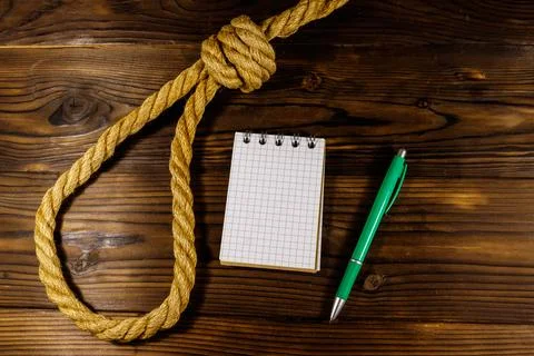 Deadly loop of rope and suicide note on a wooden background. Concept of suicide Stock Photos