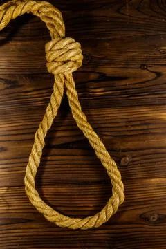 Deadly loop of rope on a wooden background. Concept of death penalty or suicide Stock Photos