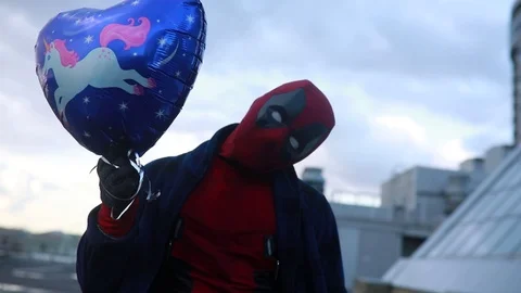 Deadpool cosplayer is having a fun with air balloon. Stock Footage 111203996