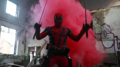 Deadpool cosplayer posing  with two swords in his hands. Stock Footage 111578883