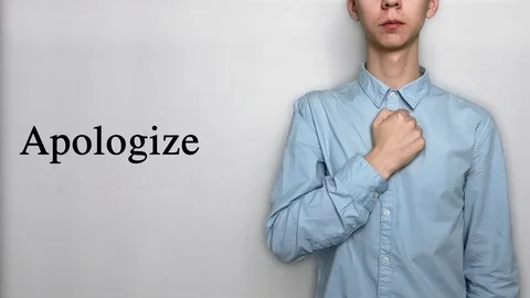 Deaf guy with Asian features in blue shirt on white background saying apologize Video stock 119284783