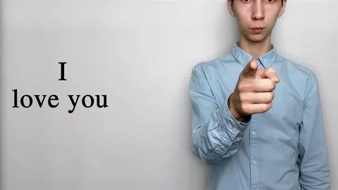 Deaf guy with Asian features in blue shirt on white background saying I love you Stock Footage 119284798