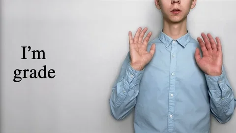 Deaf guy with Asian features in blue shirt on white background saying I'm grade Stock Footage 119284799