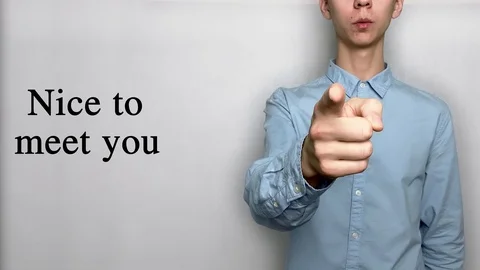 Deaf guy with Asian features in blue shirt on white background saying nice to me Stock Footage 119284815