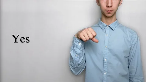 Deaf guy with Asian features in blue shirt on white background saying yes. Show Stock Footage 119284822