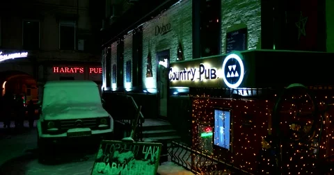 Deaf snow-covered yard, the pub sign is lit at night Stock Footage 67394667