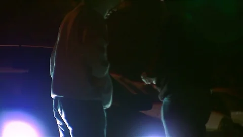 Dealer selling drugs on the street at night Stock Footage