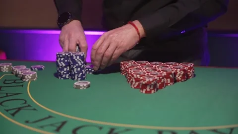 Dealer Stacking Chips Meticulously Today. Dealer Organizing Red Chips With Stock Footage 345499809