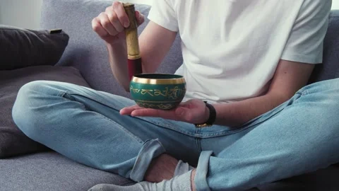 Dealing with depression and stress. Young man using tibetan singing bell bowl at Stock Footage 153057353