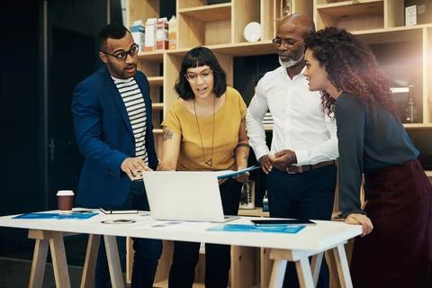 Dealing with unforeseen issues. a group of designers having a discussion in a Stock Photos