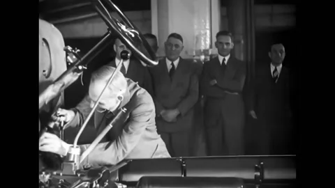 DEARBORN - 1937 - A V8 engine is displayed on a turntable, Henry Ford hammers a Stock Footage 312792964