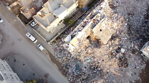 Debris scattered around a multi-storey building that collapsed in the earthquake Stock Footage 258054727