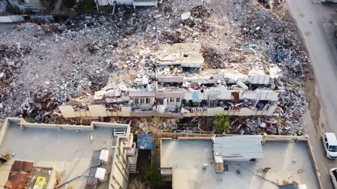 Debris scattered around a multi-storey building that collapsed in the earthquake Stock Footage 258058372