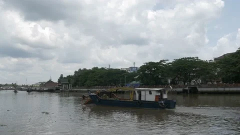 Debris skimmer cleaning up trashes and garbage on Martapura river Stock Footage 156996049