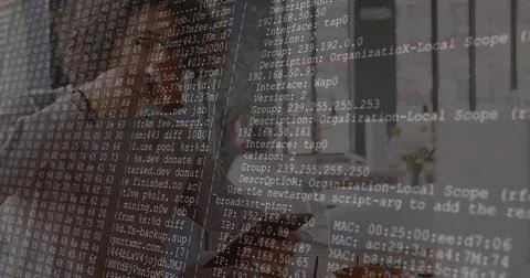 Debugging network config by professional at desk with code overlay, wearing Foto stock