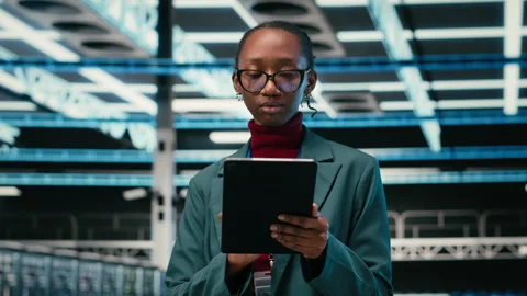 Debugging systems, tablet and female engineer walking in data center Stock Footage 329591869