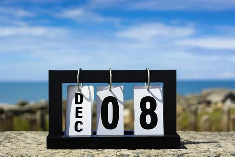Dec 08 calendar date text on wooden frame with blurred background of ocean. Stock Photos