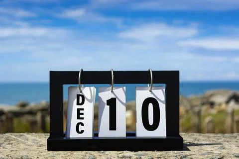 Dec 10 calendar date text on wooden frame with blurred background of ocean. Stock Photos