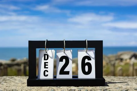 Dec 26 calendar date text on wooden frame with blurred background of ocean. Stock Photos