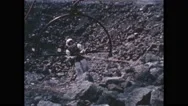 Decade: Person In Spacesuit Holds On To Rope And Frame On Rocky Ground. Space Stock Footage