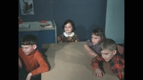 Decade: Students sitting at desks sing along with teacher playing on piano. Stock Footage 188531044