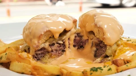 Decadent Close-Up of a Melted Cheese-Covered Rarebit Burger with Fries Stock Footage 331633498