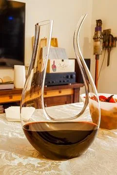 Decanter with red wine on the table. Pour red wine into the decanter. Stock Photos
