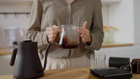 Decanting fresh brewed v60 coffee in server on kitchen at white cozy home Stock Footage 254737969