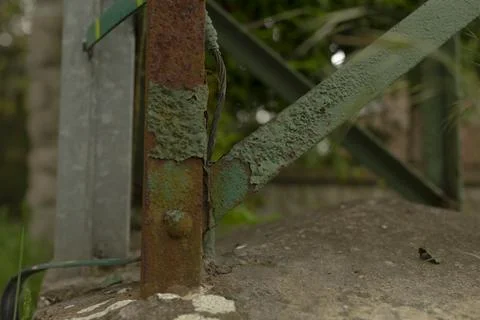 Decay on metallic support beam. Aged metal pole with peeling paint and moss Stock Photos