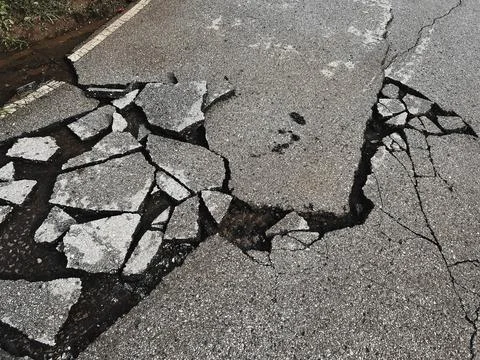 Decayed road paved asphalt distressed road surface with damaged, peeling dama Foto stock