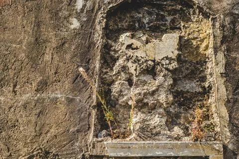 Decayed Stone Niche with Peeling Plaster and Plants 스톡 사진