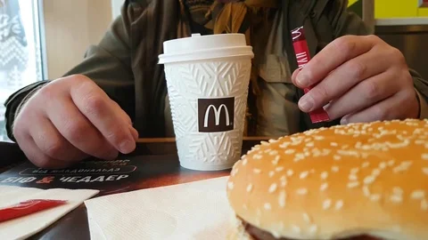December 7, 2017 Ukraine Kiev man pours sugar in coffee in McDonald's restaurant Stock Footage 83200218
