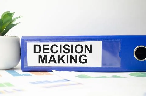 Decision making words on blue file folder and charts Stockfoto's