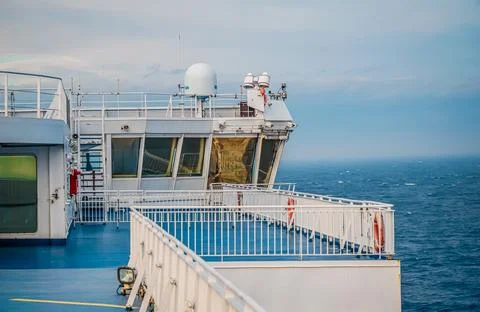 The deck area of an expansive large ship featuring a white railing Stock Photos