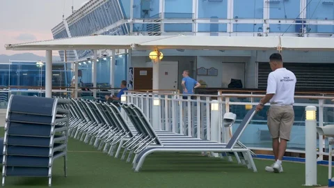 Deck Attendant sets out lounge chairs aboard cruise ship Stock-Footage 107696061