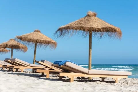 Deck chairs and straw umbrellas on the wonderful island of Formentera in Spai Фото