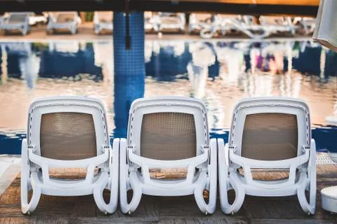 Deck chairs near the pool Stock Photos