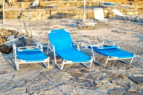 Deck chairs on a sandy beach Stock Photos